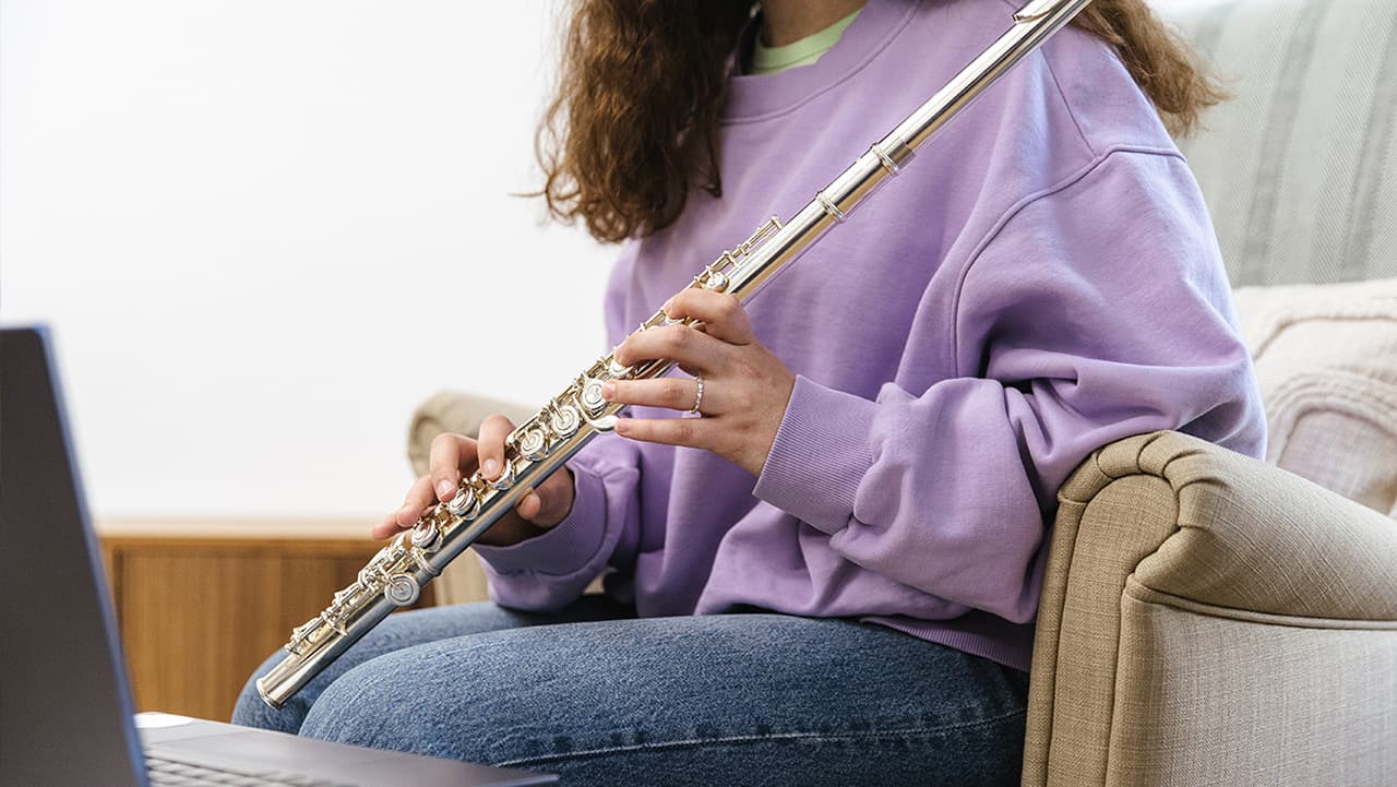 photo of a girl learning how to play the flute during a virtual leason